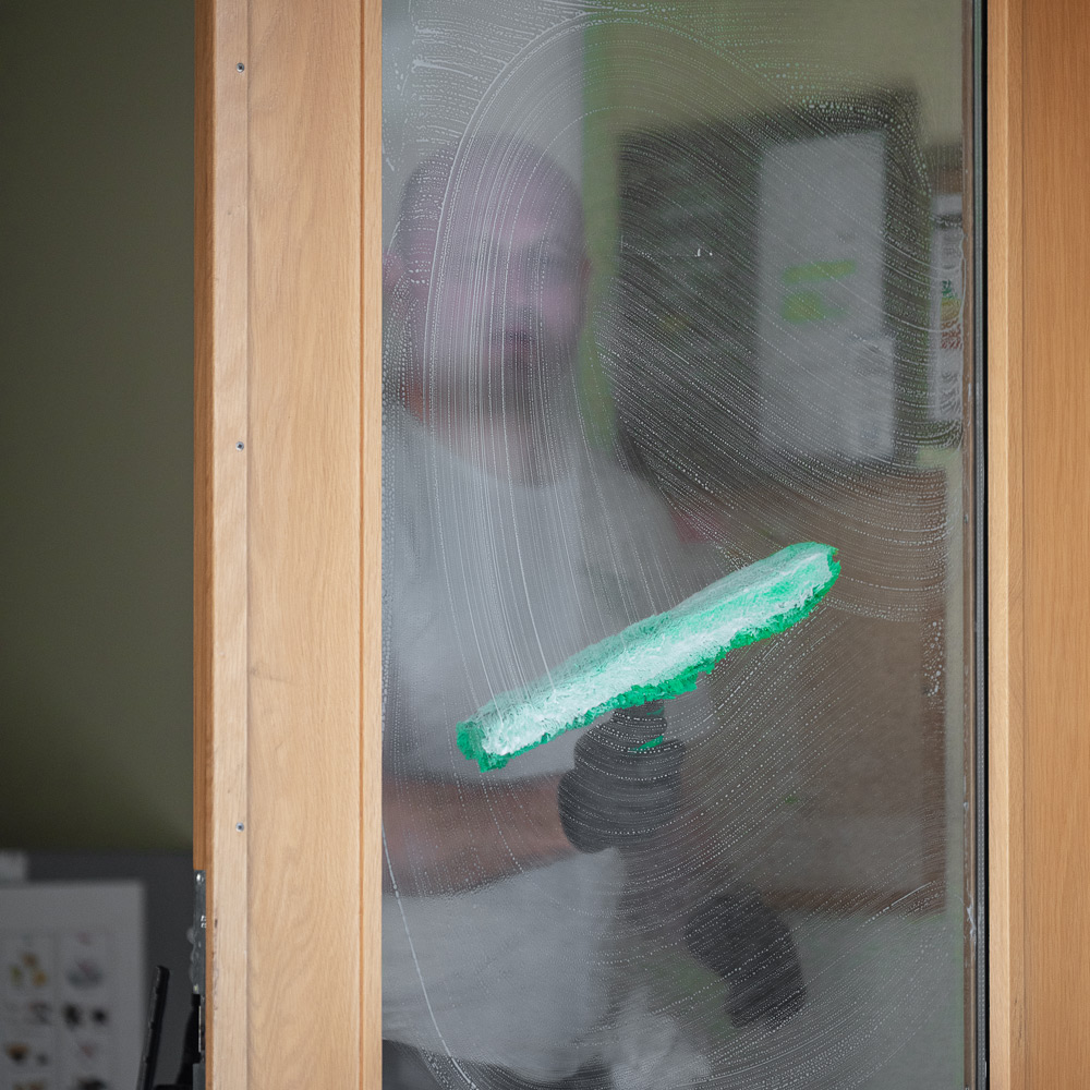 En bild på en anställd som putsar fönster